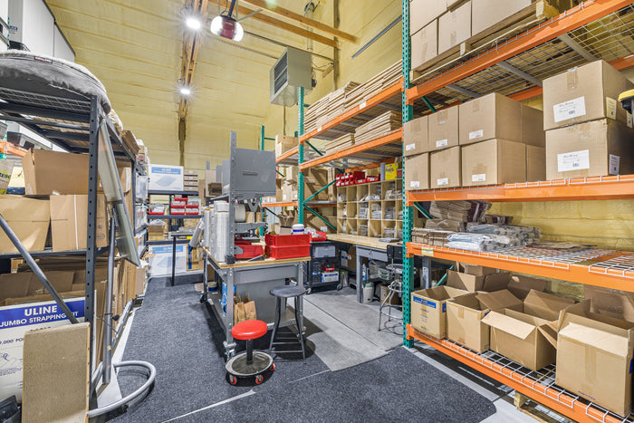 The packing station in Pop's Birding's Idaho warehouse, with workbenches, shipping supplies and shelves of boxed orders