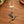 Brass hummingbird charm on a gold swivel clasp, on a wooden table