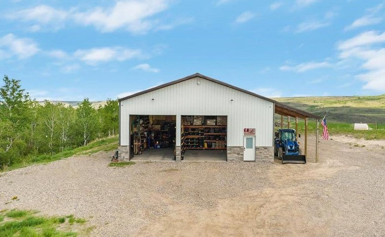 Pop's first shop in Idaho, a metal building with open bay doors, shelves of inventory and an American flag