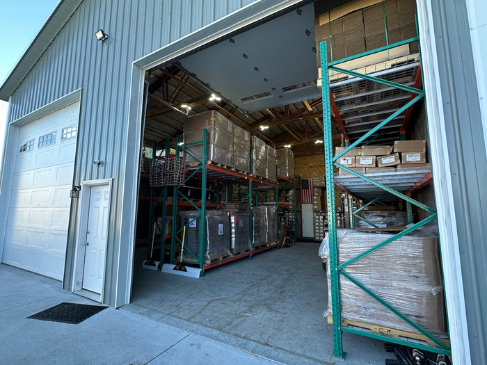 The open bay door of Pop's Birding's Idaho warehouse, with racks of stocked inventory inside
